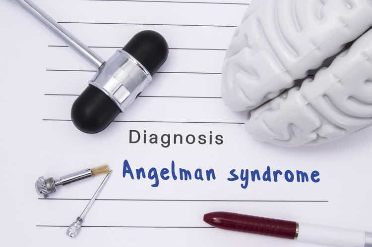 Diagnosis of Angelman syndrome. Neurological hammer and brain figure lie on a medical paper form with a heading diagnosis of Angelman syndrome on a table in the office of a neurologist