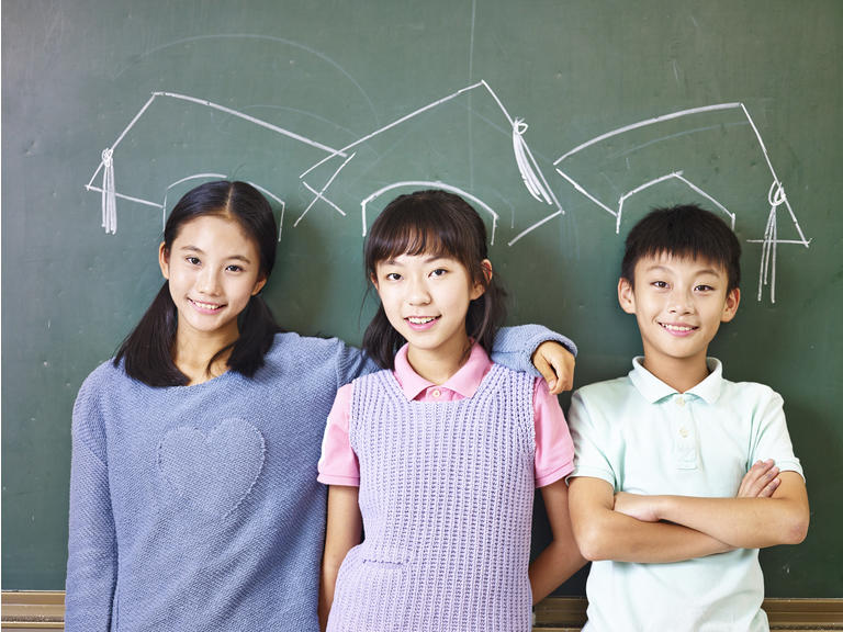 asian school children with chalk-drawn mortarboards
