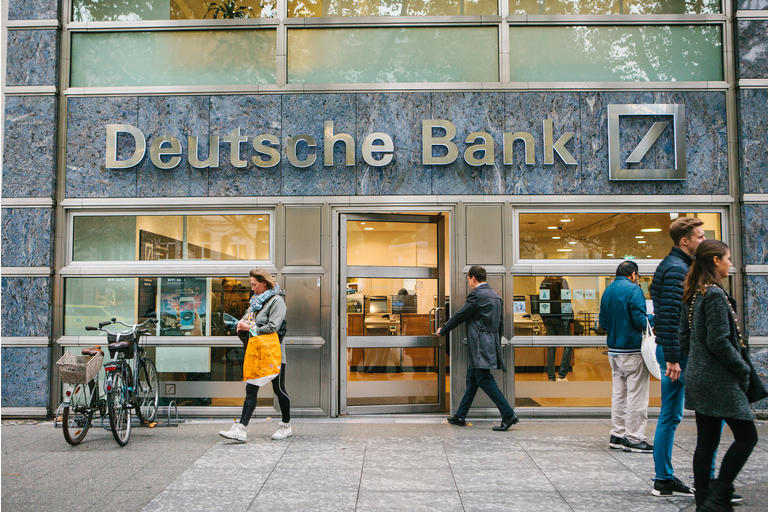 Unknown man walks into the beautiful glass office of Deutsche Bank