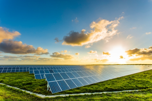 Solar panels at sunrise with cloudy sky in Normandy, France. Solar energy, modern electric power production technology, renewable energy concept. Environmentally friendly electricity production