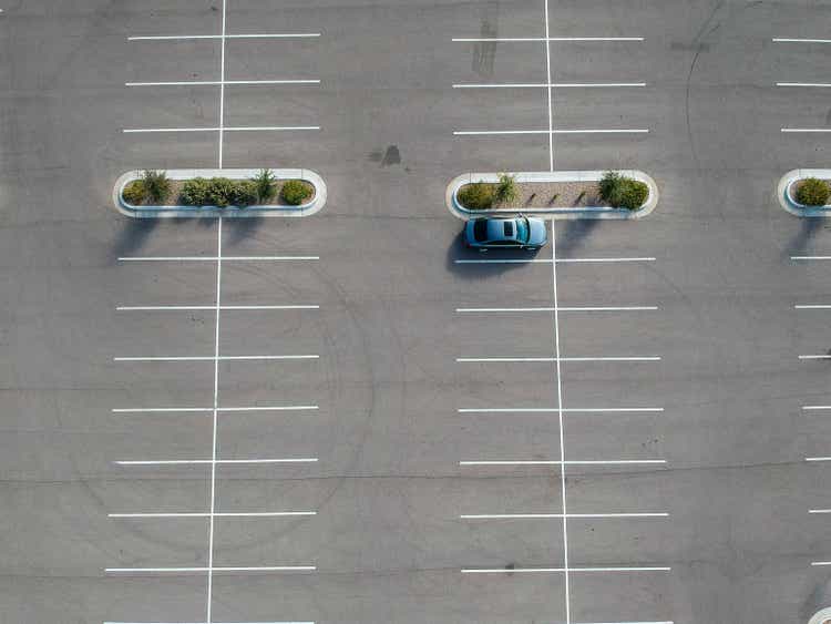 A car parked at a large parking lot.