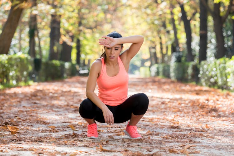 young beautiful and attractive sport woman in runner sportswear breathing gasping and taking a break tired and exhausted after running workout on Autumn