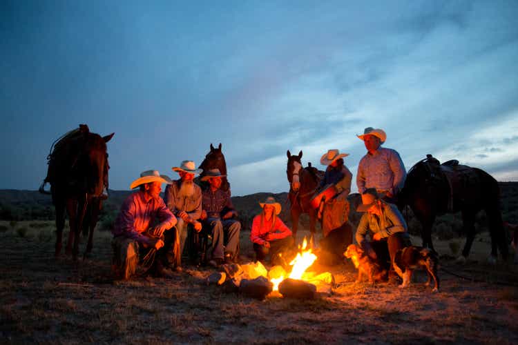 Group of Cowboys and Cowgirls Sharing a Bonfire at Dusk