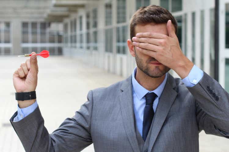 Blind businessman holding darts