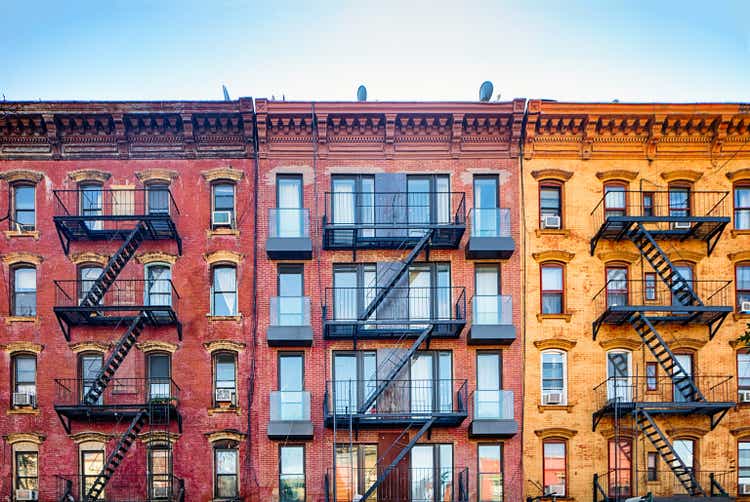 Top stories of colorful Williamsburg apartment buildings with steel fire escape stairways