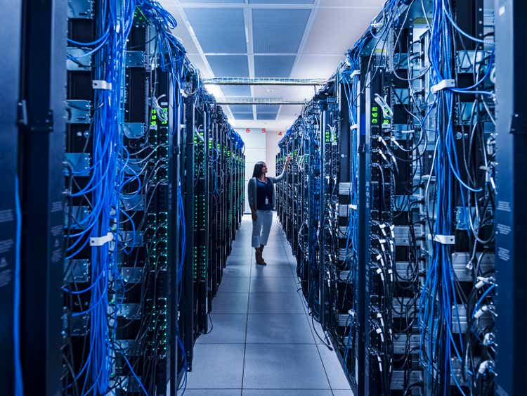 Woman standing in aisle of server room