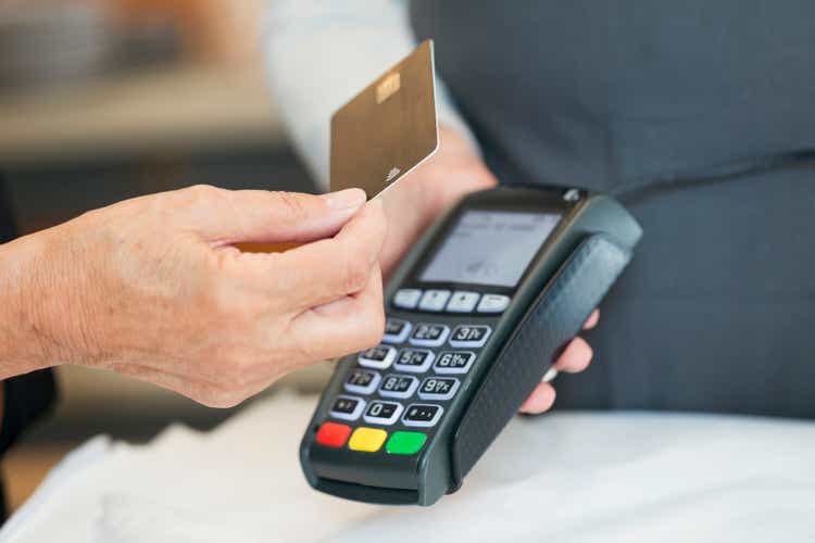 Close up of senior woman using contactless payment in shop