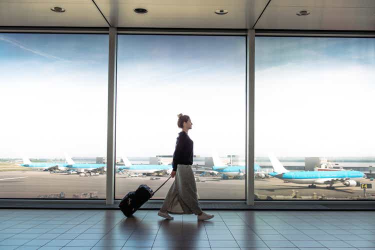 Woman with suitcase is going to board on the next flight