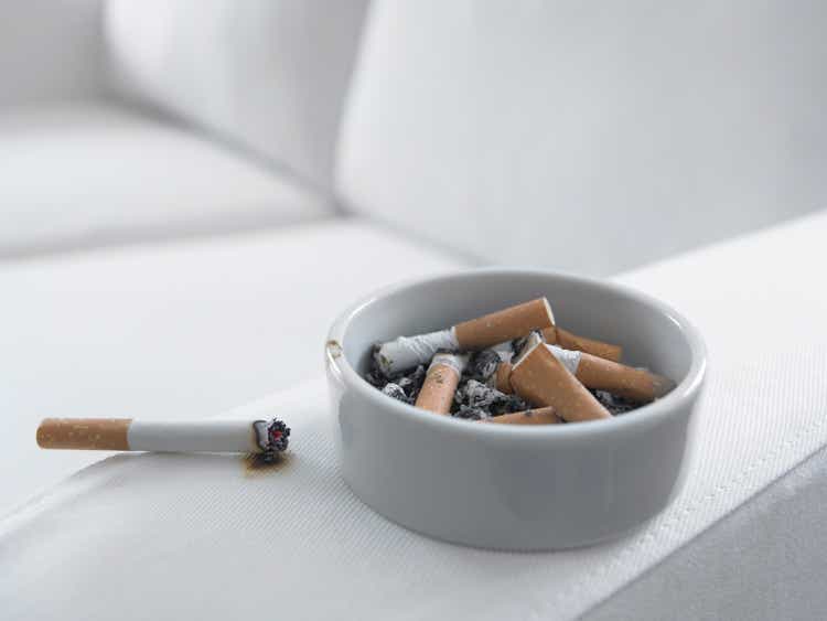 Cigarette burning arm of sofa