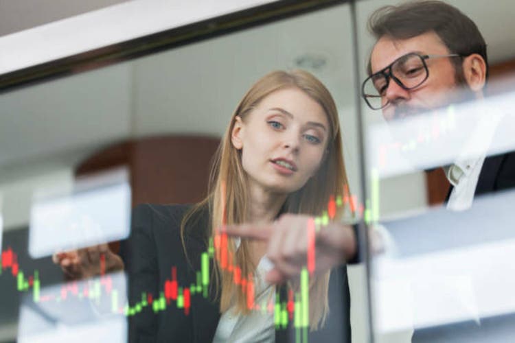 Businesswoman and businessman talking profit on futuristic display