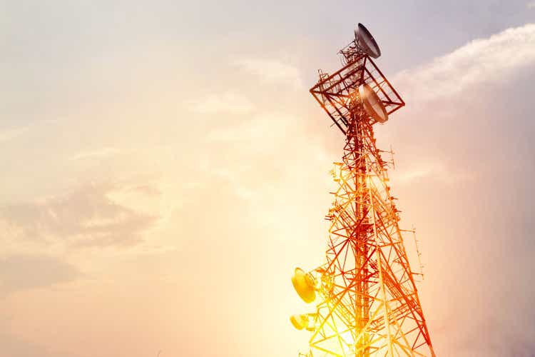 Abstrakti tietoliikennetorni Antenni ja satelliittilautanen auringonlaskun taivaan taustalla