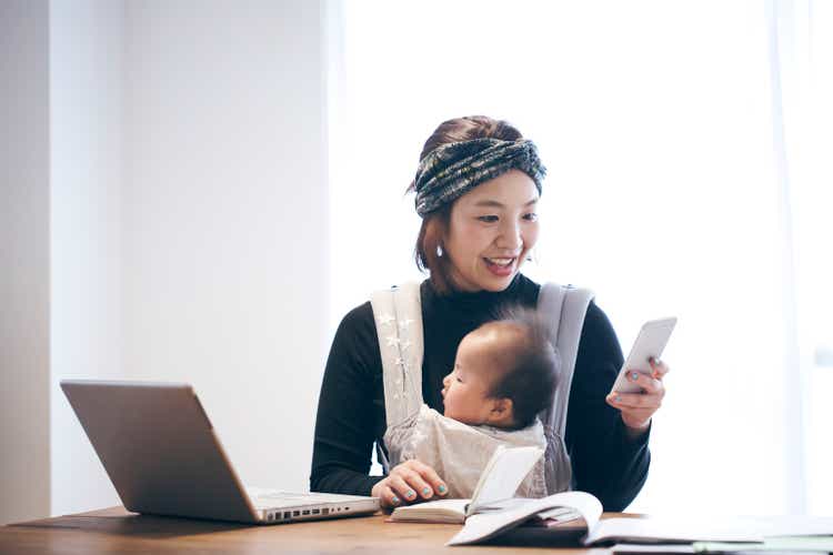Mother with baby working at home