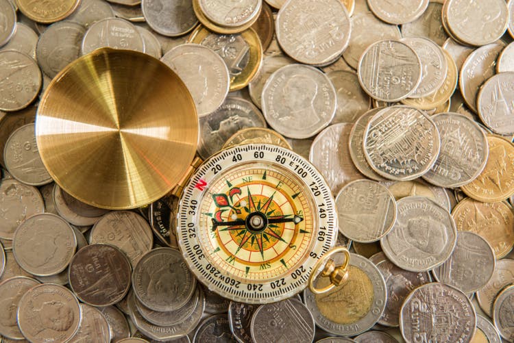 Coins and compass on the vintage map