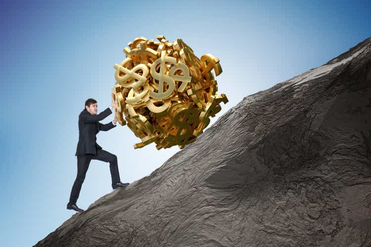 Sisyphus metaphore. Young businessman is maximizing earnings and pushing heavy boulder made of dollar symbol up on hill.