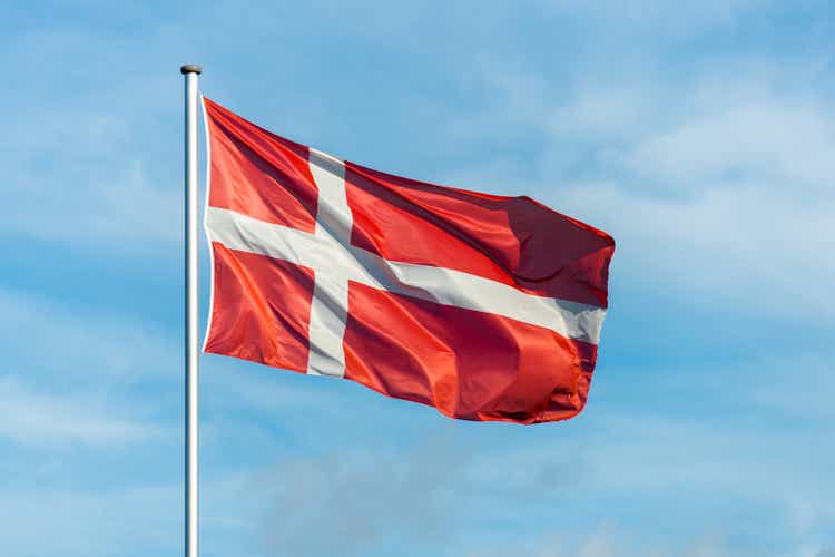 Dänische Flagge wackeln im Wind mit Himmel im Hintergrund