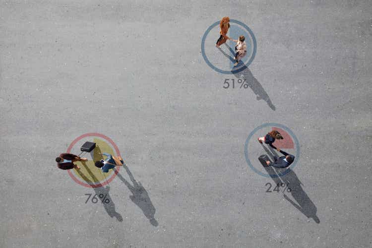 Top view of businesspeople making handshakes, while standing inside painted pie charts