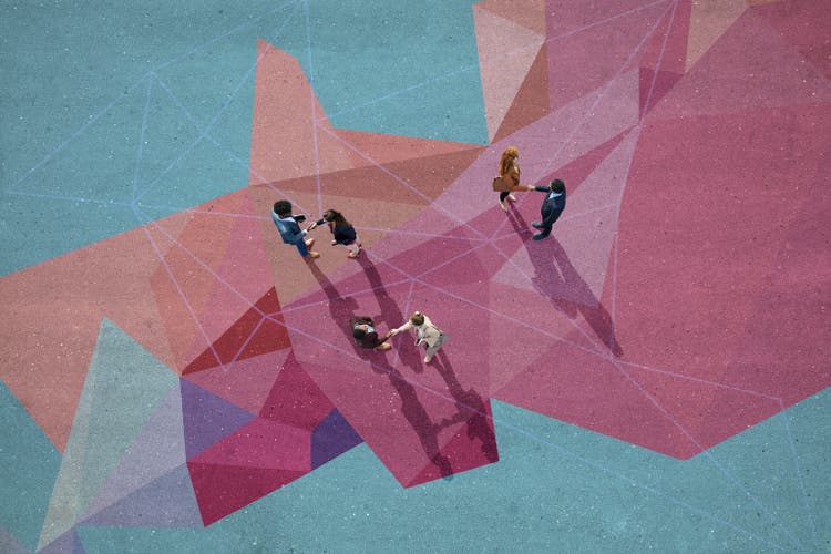 Businesspeople making handshakes, while standing on painted pattern on asphalt