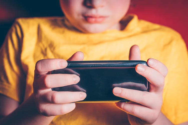 Uma criança está segurando um smartphone