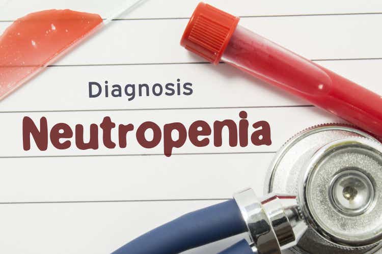 Diagnosis of Neutropenia. Medical book with text header hematological diagnosis Neutropenia lies on table surrounded by laboratory test tubes with blood, glass slide with blood smear and stethoscope