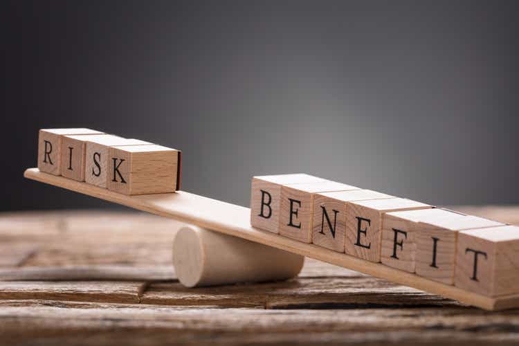 Closeup Of Risk And Benefit Wooden Blocks On Seesaw