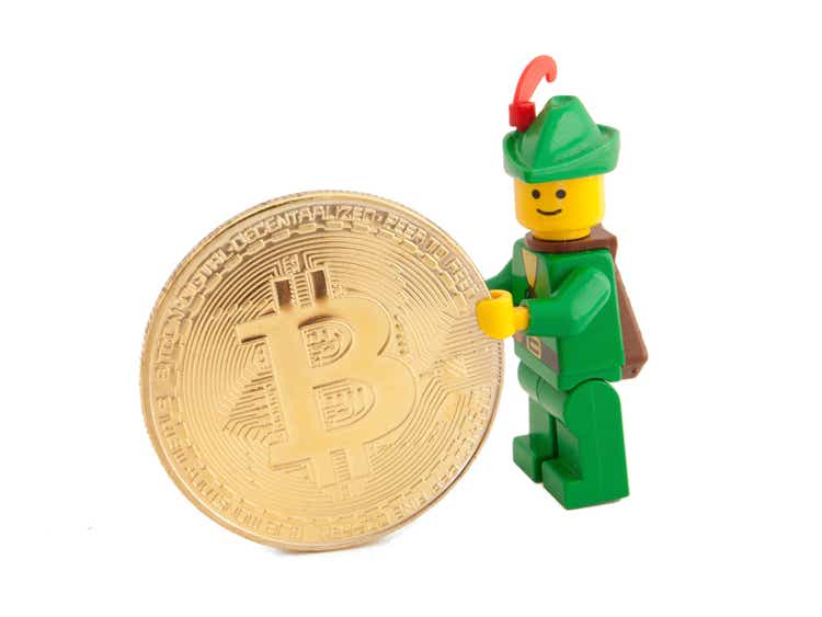 Robin Hood (as Lego figure) standing next to Bitcoin coins