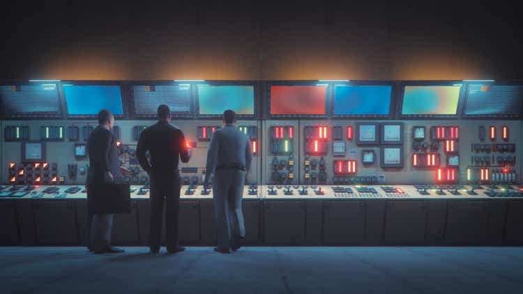 Retro underground control room with men in front of the console