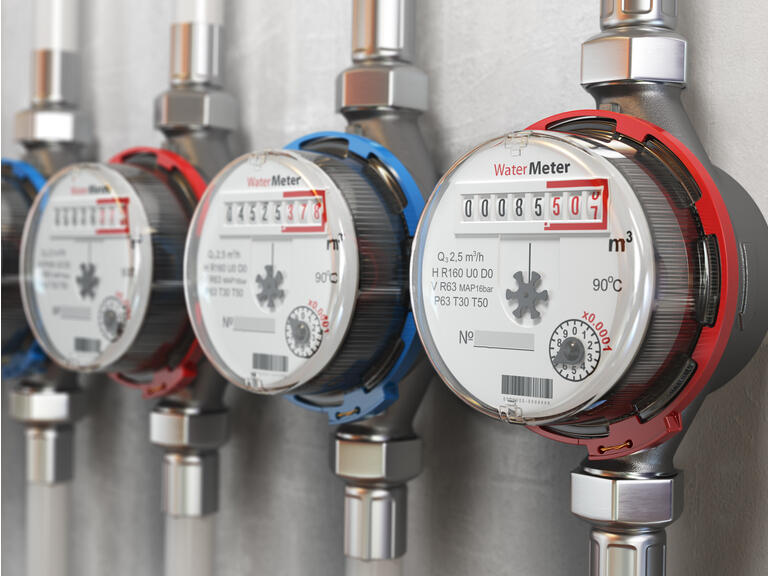 Row of water meters of cold and hot water on the wall background.