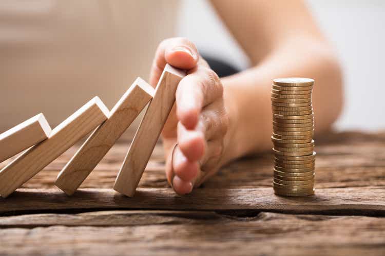 Close-up Of A Businesswoman"s Hand Stopping Falling Blocks