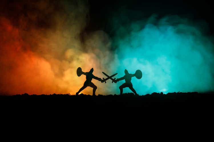 Medieval battle scene with cavalry and infantry. Silhouettes of figures as separate objects, fight between warriors on dark toned foggy background. Night scene.