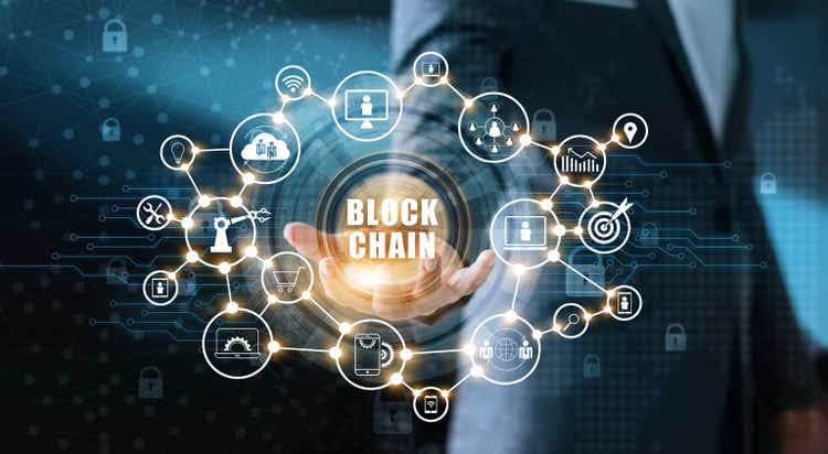 Blockchain technology and network concept.  Businessman holding text blockchain in hand with icon network connection on blue security and digital connection background