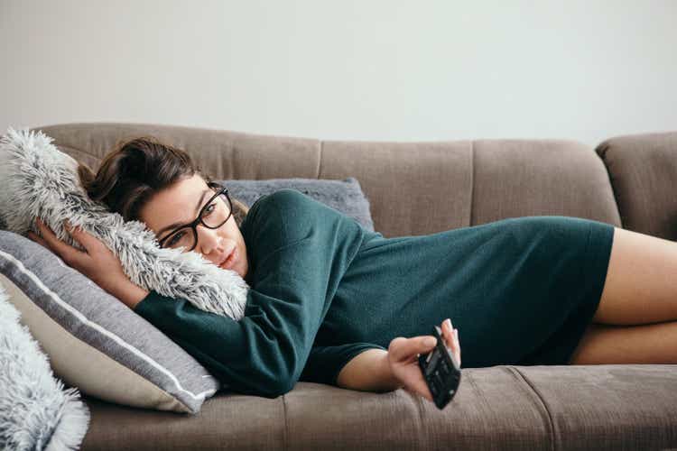 Depressed Woman Changing Channels on a TV Remote