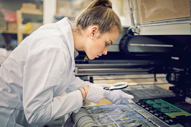Woman is working with resistors pick and place machine in circuit board factory