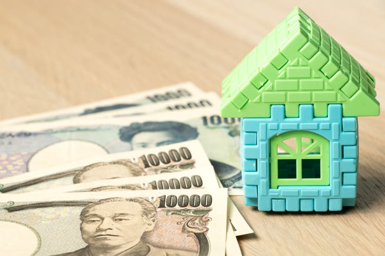 Japanese yen with home model object on wood desk background