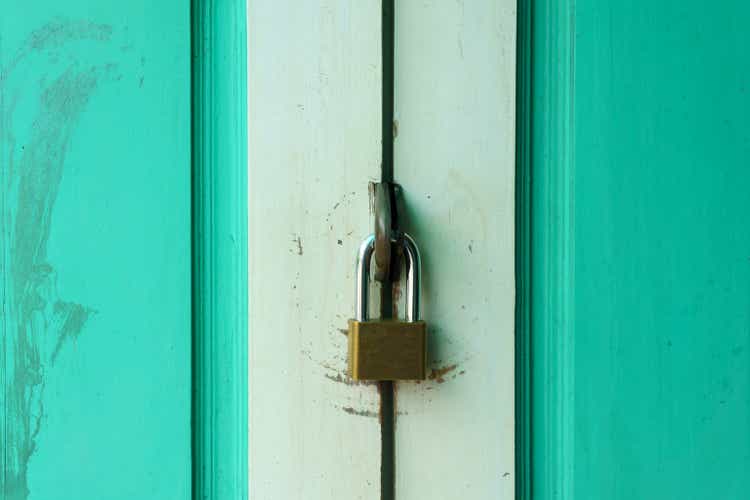 close up of masterlock on the old green vintage door.