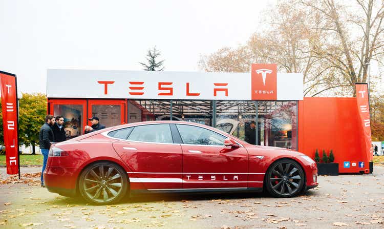 New Tesla Model S showroom parked in front of the red showroom