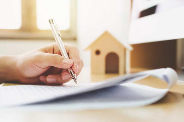 Close-up hands of man signing home ownership signature loan documents.Mortgages and real estate investments