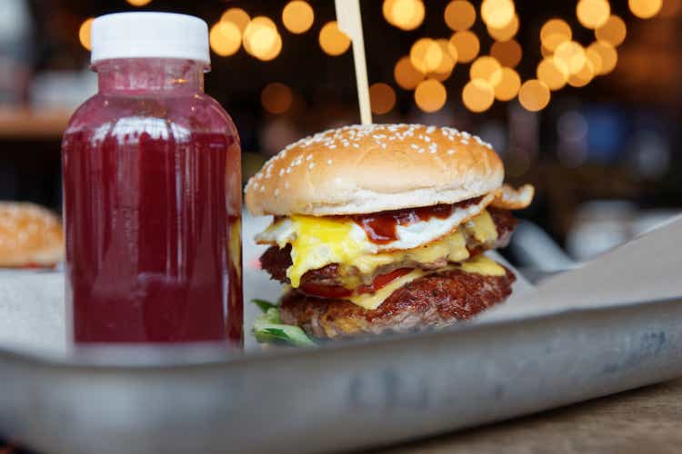 Burger and berry smoothie on metal tray