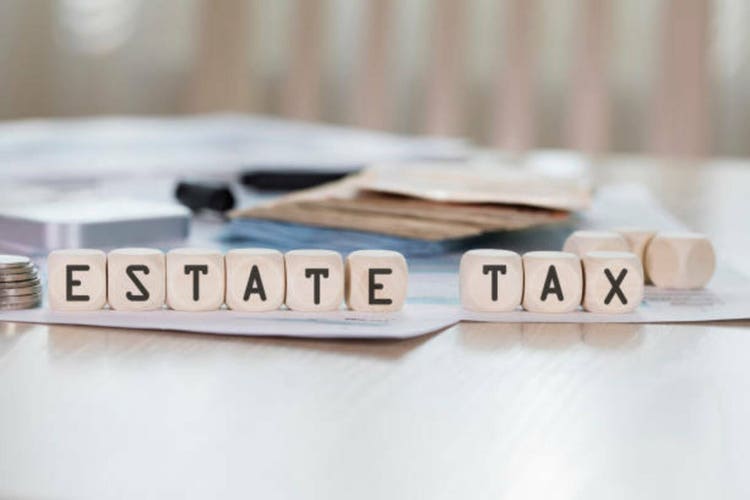 Word ESTATE TAX is composed of wooden letters.