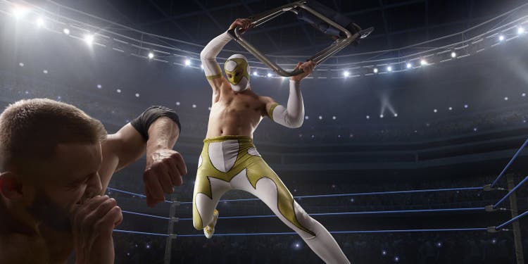 Wrestling show. Two wrestlers in a bright sport clothes and face mask fight in the ring