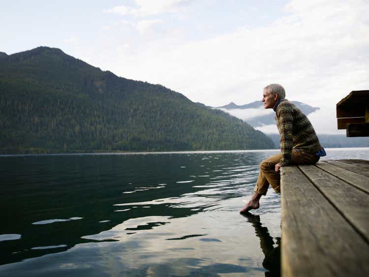 Man sitting on edge of dock with feet in water