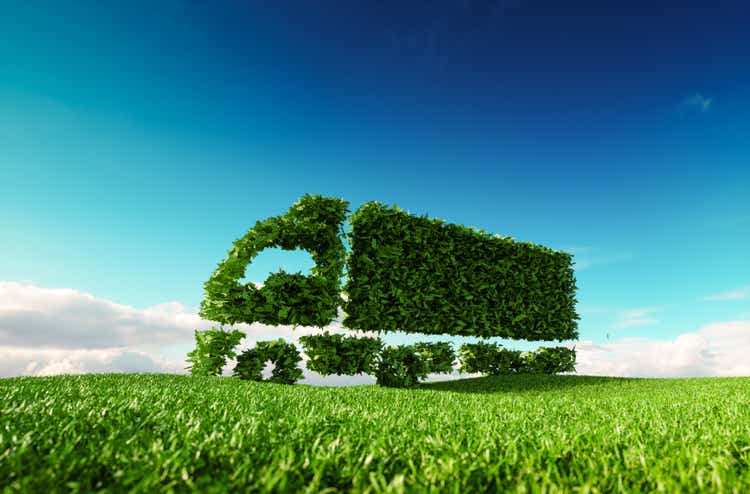 Eco-freundliche Transport-Konzept. 3D-Rendering des grünen grünen Lastwagen-Symbol auf frische Frühlingswiese mit blauen Himmel im Hintergrund.