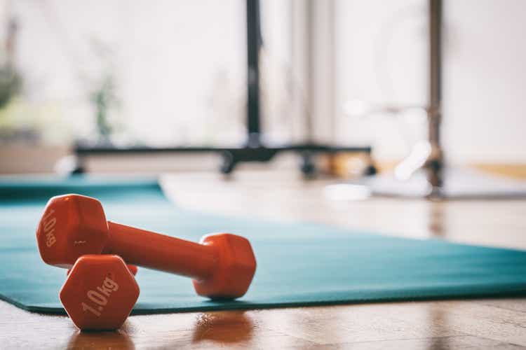 Pair of orange dumbbells on a wooden floor