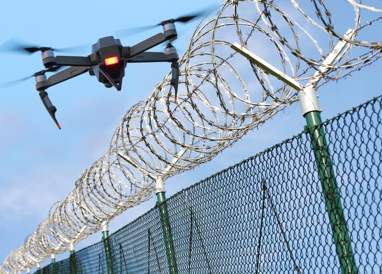 Drone monitoring barbed wire fence on state border or restricted area.