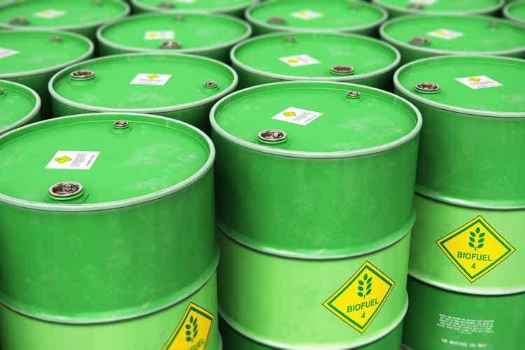 Group of rows of green stacked biofuel drums in storage warehouse