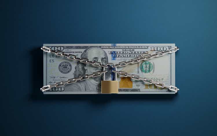 One Hundred American Dollar Banknote Tied With A Padlock And Chain One Blue Background