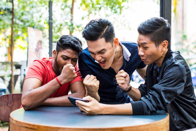 Group of friends watching their favorite match on a mobile phone