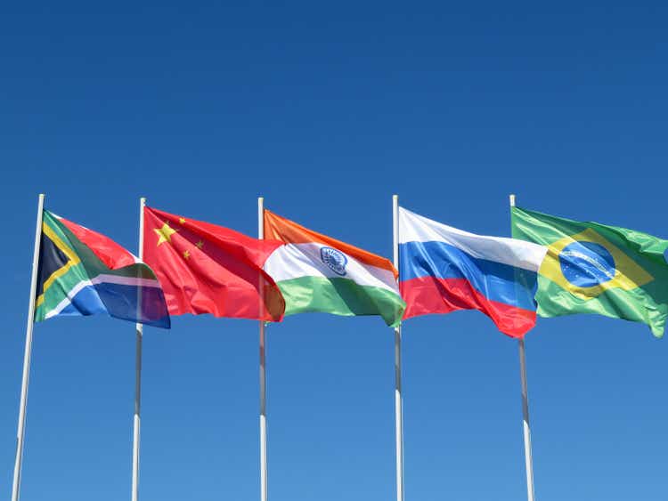 Waving flags of the BRICS countries against the blue sky