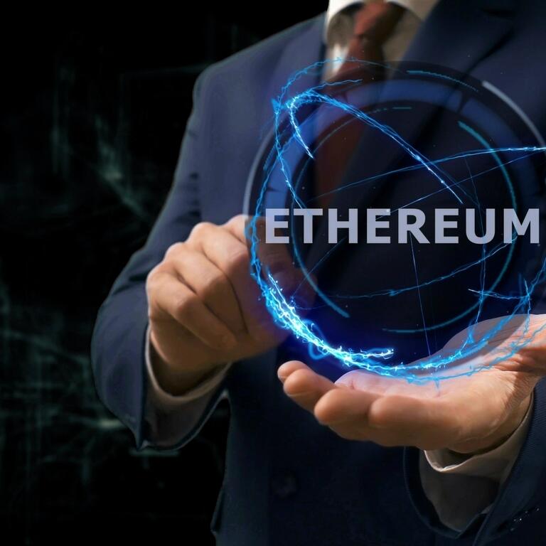 Businessman shows concept hologram Ethereum on his hand