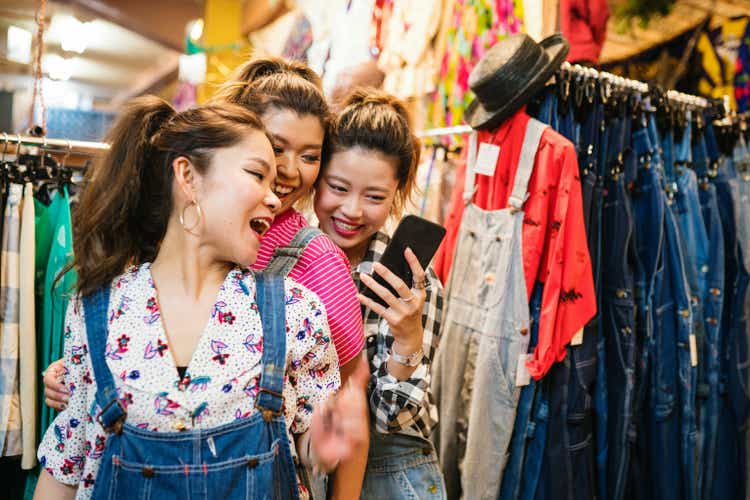 Three young woman shopping in a vintage clothing store