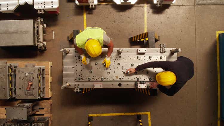 Manuel Worker in a Production Line of a Machine Part